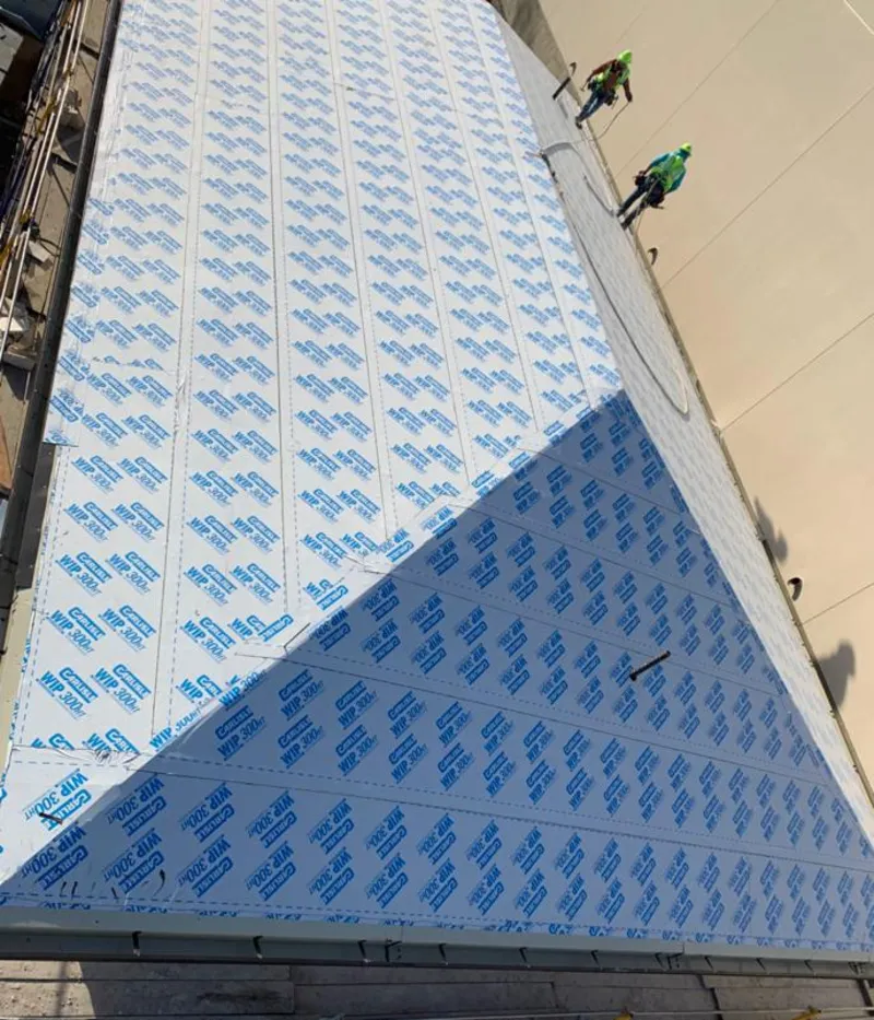 Professional roofers installing underlayment on a metal roof in Livingston